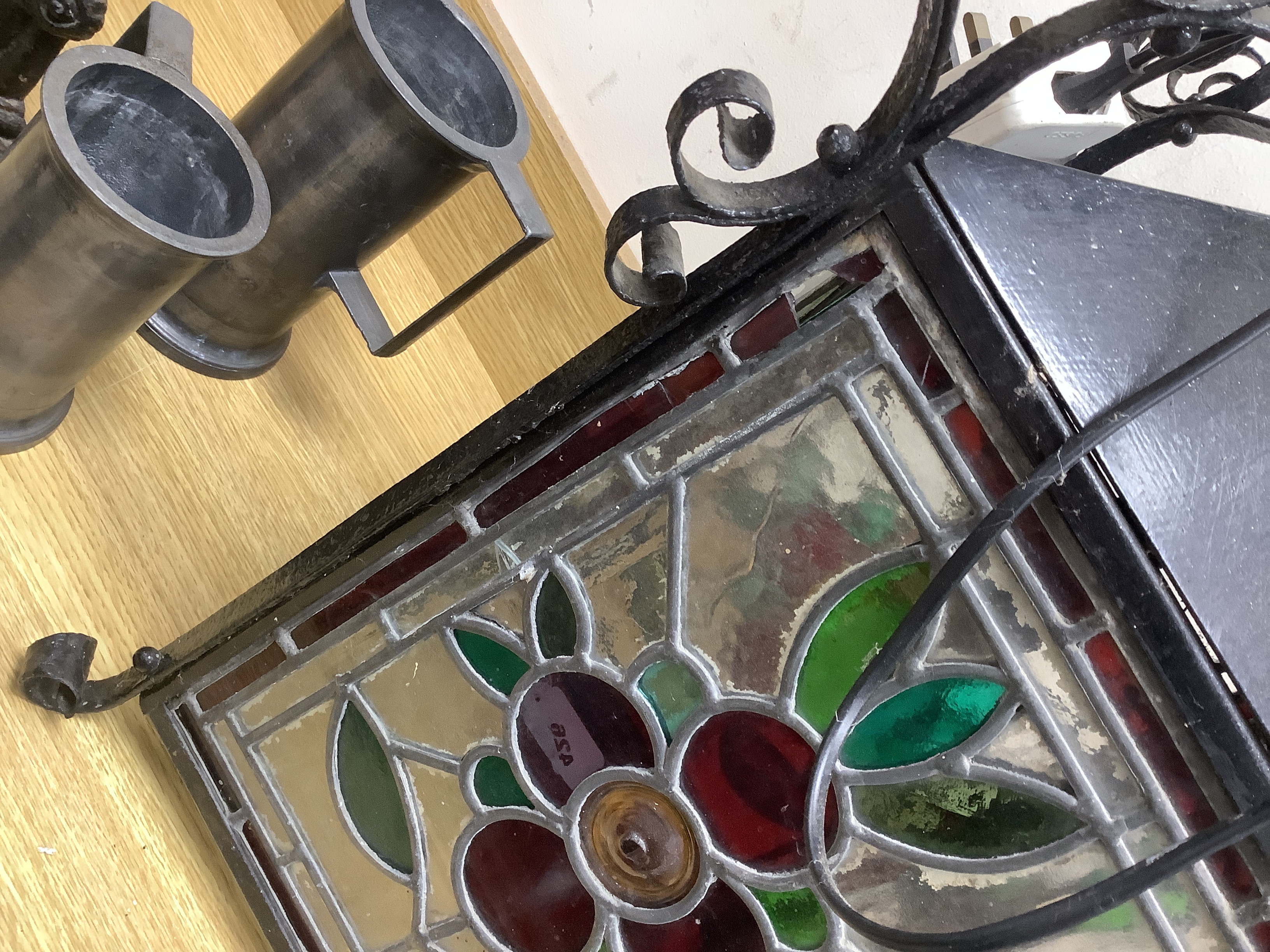 A late 19th/early 20th century Arts and Crafts style wrought iron and stained glass panelled hanging lantern, 80cms high